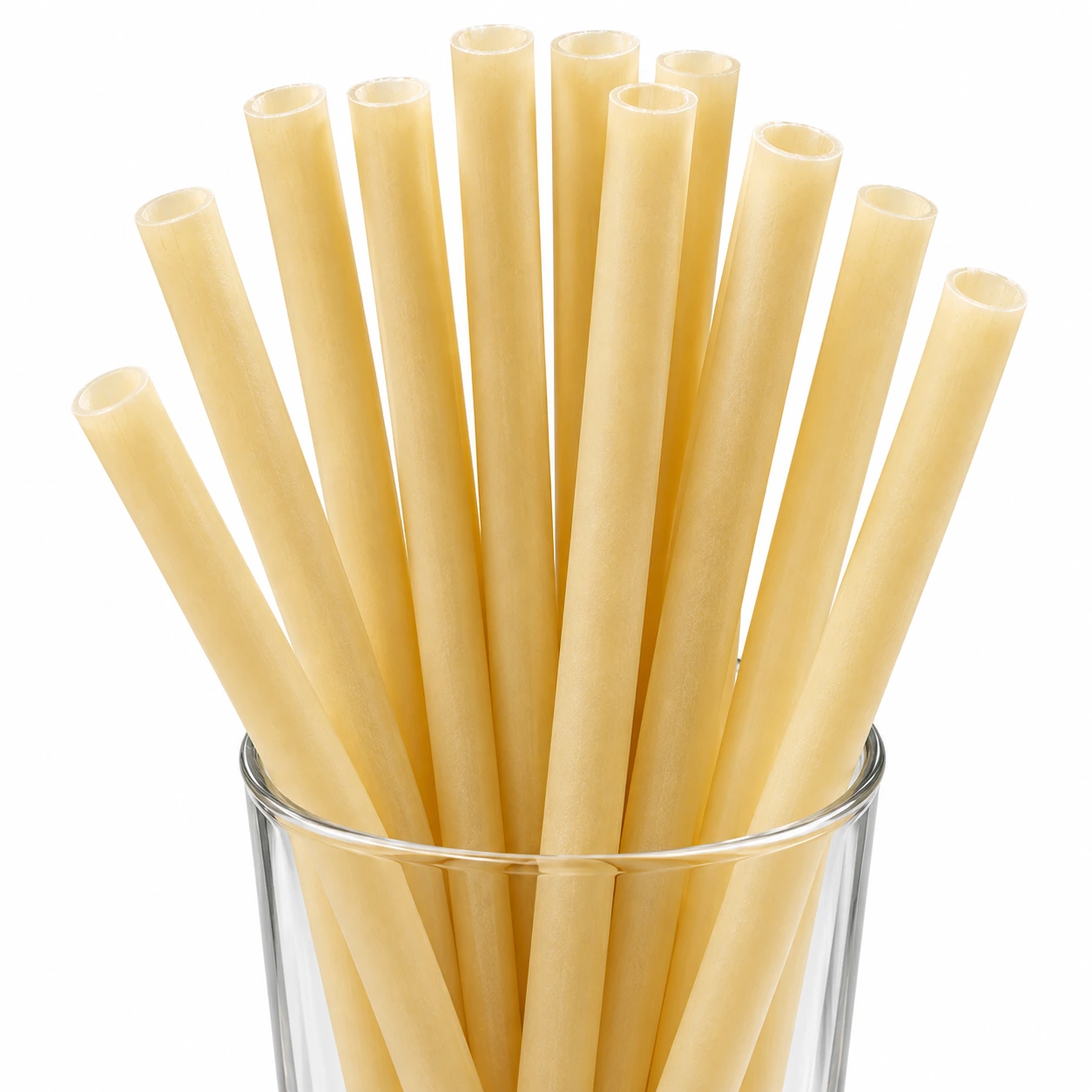 NOMS rice straws in their natural golden-beige rice color, standing in a clear glass.